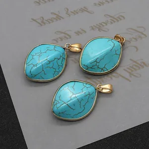 Detalle de colgantes de turquesa en forma de marquesa con borde dorado y vetas naturales