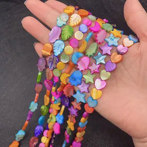 Close-up of colorful mother of pearl shell beads in Hamsa and star shapes for DIY