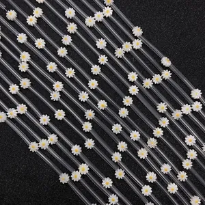 Transparent plastic straws featuring white daisy floral patterns with yellow centers