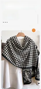 Detail of black and white houndstooth cashmere shawl with short fringe tassels on the edge