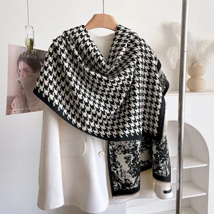 Close-up of thick houndstooth scarf with soft fringe edges and patchwork texture
