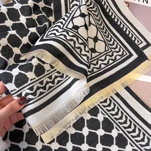 Gros plan détaillé d'une écharpe jacquard géométrique noire et blanche à franges fines