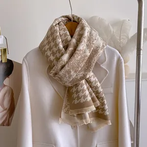 Detail of houndstooth scarf with fine tassels styled on a white winter coat