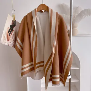 Detail shot of brown cashmere shawl with stripes, tassels and handmade label finish