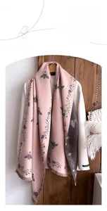 Detailed view of pink and grey faux cashmere scarf with vintage bee and flower patterns
