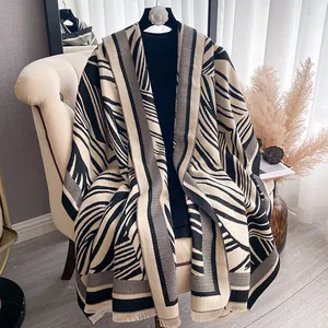 Detail of zebra pattern cashmere feel shawl with elegant fringe and geometric knit texture