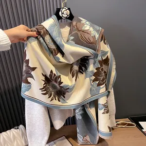 Elegant knit sunflower pashmina scarf in beige and blue, styled on a garment hanger