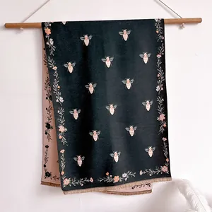 Detail of vintage jacquard scarf showing green bee pattern and soft fringe edges