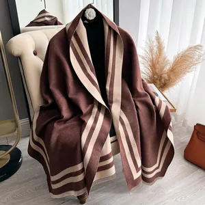 Detail of soft brown cashmere-like shawl featuring elegant cream stripes and fringe trim