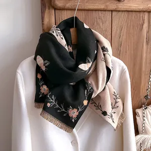 Detail of the vintage floral and bee jacquard pattern with fringe on the knitted scarf