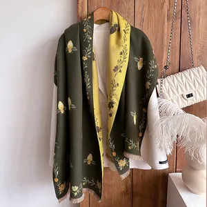 Detail of vintage floral bee pattern on reversible green and yellow cashmere shawl