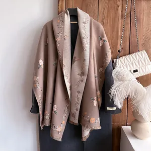 Retro jacquard knit scarf with bee embroidery and fringe on a charcoal coat