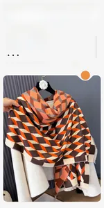 Detailed close-up of orange and brown diamond pattern scarf with soft fringe edges