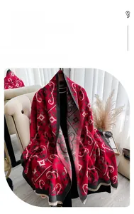 Detailed view of the red faux cashmere scarf with vintage floral patterns and fringe edges