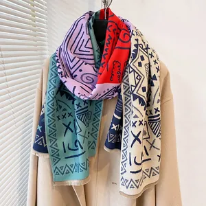 Detail of colorful geometric graffiti pattern scarf with fringe on a beige coat