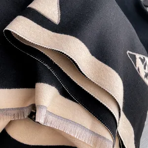 Close-up of double-sided floral pattern cashmere scarf with delicate tassel edges