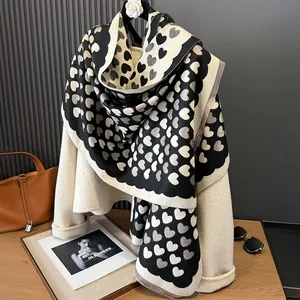 Detail of soft heart pattern scarf with wavy edges and fringe on a neutral outfit
