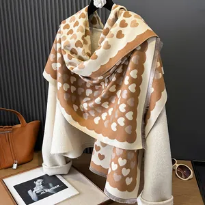 Detailed view of thick cashmere scarf with heart pattern and scalloped edges