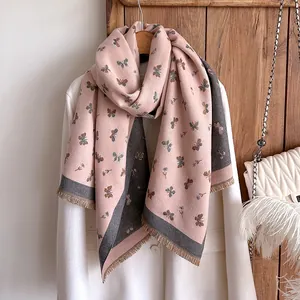 Detail of pink pashmina shawl with butterfly print and fringe edges on a blazer