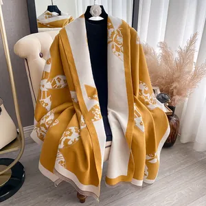 Detail of floral cashmere-like shawl featuring yellow flower patterns and fringe edges
