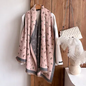 Pink and grey cashmere scarf with butterfly print and tassels on white winter coat