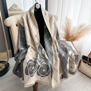 Detail of camellia flower brooch on thick cashmere-like scarf with diamond lattice pattern