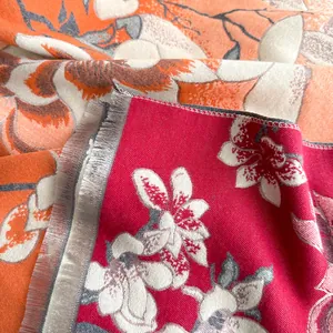 Primer plano de tela jacquard de alta gama con motivos de magnolia en rosa y naranja