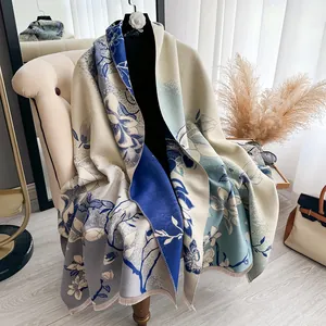 Detalle de un elegante chal jacquard con motivos florales, borlas y suave tejido de punto