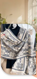 Detail of grey and beige imitation cashmere scarf with geometric patterns and short fringes
