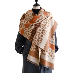 Écharpe à carreaux avec ours de dessin animé et franges sur mannequin en manteau gris