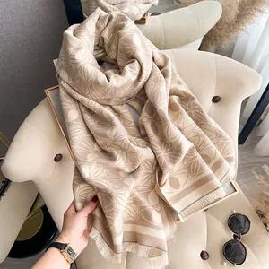 Close-up of khaki and beige jacquard floral shawl with soft fringed tassel details