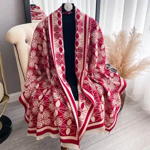 Detail of red and beige geometric floral pattern on thick scarf with fine fringe trim