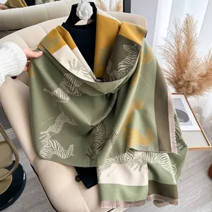 Close-up of thick zebra pattern shawl with fringe in green, yellow and beige tones