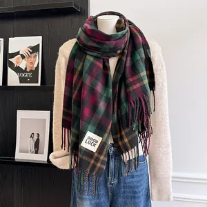 Detail of red and green plaid scarf with thick tassels and a Good Luck woven label
