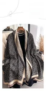 Detail of soft imitation cashmere scarf with geometric patterns and short fringe trim