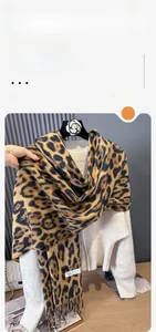 Close-up of leopard print cashmere scarf with fringe tassels and wash label detail