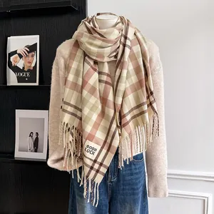Detail of plaid scarf with tassels and Good Luck patch on a beige sweater