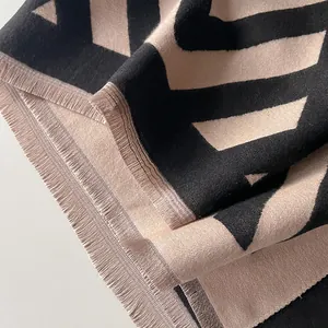 Détail de l'écharpe en tissu tissé épais avec motifs ondulés et bords à franges
