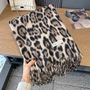 Close-up of leopard print cashmere scarf texture with 100% Pashmina label and fringe