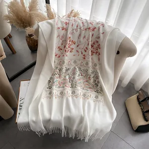 Detail of elegant white pashmina shawl featuring intricate floral and paisley embroidery