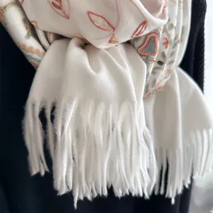 White cashmere-style scarf with colorful ethnic floral embroidery and tassel fringe