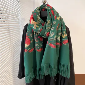 Détail de la broderie de feuilles de grenade sur une écharpe verte au toucher cachemire