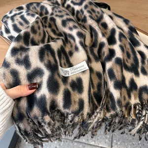 Detail of soft leopard print cashmere scarf with fringe edges and 100% cashmere label