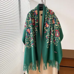 Dettaglio del ricamo floreale paisley e frange sullo scialle in cashmere verde scuro