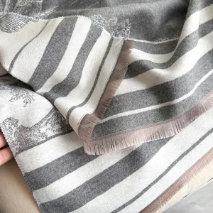 Klassischer grau-weißer Jacquard-Schal mit weicher Strickstruktur und Fransen