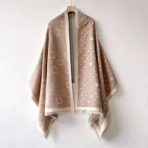 Détail d'un châle premium effet cachemire avec motifs roses et gris et finitions franges