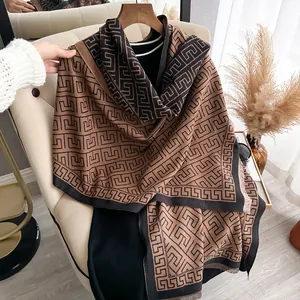 Detailed view of geometric patterns and soft fringe on the brown cashmere-like shawl