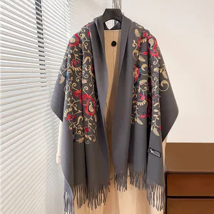 Dettaglio scialle in cashmere con ricamo paisley, motivi floreali colorati e bordi con frange