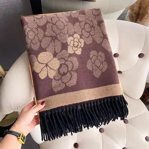 Detail of camellia flower pattern on thick brown and beige cashmere-like scarf with fringe