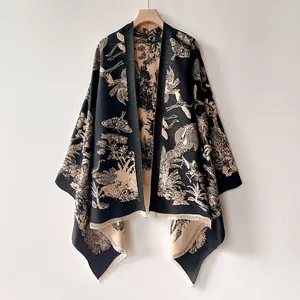 Détail du châle rétro noir avec broderie papillon beige et des franges élégantes en bas